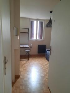 een lege kamer met een tafel en een stoel in een kamer bij Studio Jean Jaures in Chalon-sur-Saône