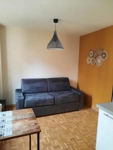 a living room with a blue couch and a table at Studio Jean Jaures in Chalon-sur-Saône