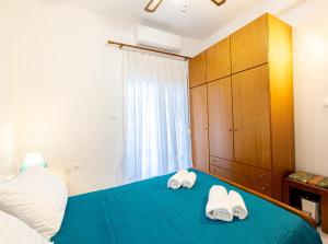 a bedroom with two towels on a blue bed at Isidora Summer House in Skala Fourkas