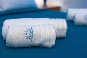 two white towels with a drawing on them on a bed at Isidora Summer House in Skala Fourkas