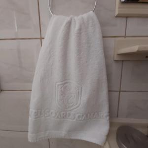 a white towel hanging on a rack in a bathroom at HOTEL SOARES CAMARGO in Salesópolis
