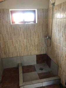 a bathroom with a shower with a window at Cabaña La Sencillita in Neptunia