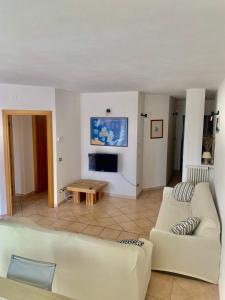 a living room with a couch and a table at Appartamento Centrale, con posto auto. in La Maddalena