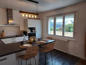 eine Küche mit einem Tisch und Stühlen sowie einem Fenster in der Unterkunft Maison au cœur du bourg, plages à pied in Plougasnou