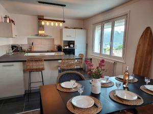 eine Küche und ein Esszimmer mit einem Tisch und Stühlen in der Unterkunft Maison au cœur du bourg, plages à pied in Plougasnou