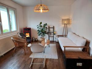 ein Wohnzimmer mit einem weißen Sofa und einem Tisch in der Unterkunft Maison au cœur du bourg, plages à pied in Plougasnou