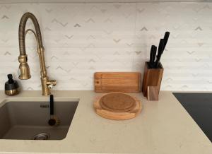 a kitchen counter with a sink and a cutting board at Sassi Apartment in Tartu +26 photos