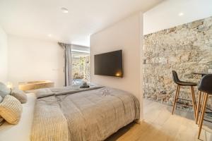 a bedroom with a bed and a tv on the wall at Villa Harmony in Supetar