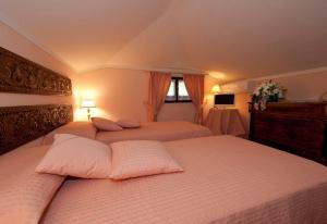 Conca di Sopra Home في Corsanico-Bargecchia: غرفة نوم بسريرين مع شراشف وردية