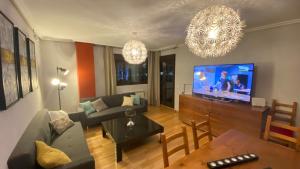 a living room with a couch and a flat screen tv at Aires de Toledo-Parque Warner y Madrid en familia in Toledo