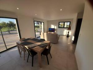 comedor con mesa y sillas y sala de estar en maison neuve a 1 km de la plage, en Saint-Germain-sur-Ay