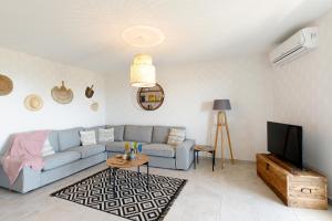 Clara YourHostHelper في مونتورو: غرفة معيشة مع أريكة زرقاء وتلفزيون
