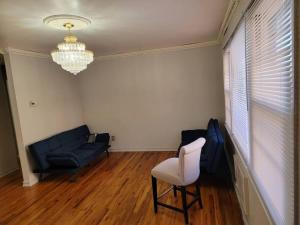 a living room with a couch and a chair and a chandelier at Private Apt Near Ferry and Park in Tompkinsville