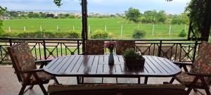 een houten tafel met 2 stoelen en een vaas met bloemen bij Hill View 4 in Alexandroupoli