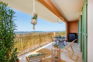 een patio met een tafel en stoelen op een balkon bij Clara YourHostHelper in Montauroux