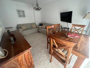 - un salon avec une table, des chaises et un canapé dans l'établissement Apartamento céntrico en Blanes, à Blanes