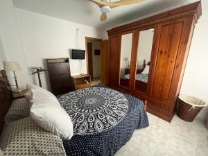 - une chambre avec un grand lit et une armoire en bois dans l'établissement Apartamento céntrico en Blanes, à Blanes