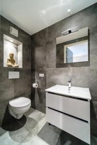 a bathroom with a toilet and a sink and a mirror at Villa Harmony in Supetar