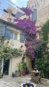 un edificio con una mesa y un árbol con flores púrpuras en L'ISLE en Beaucaire