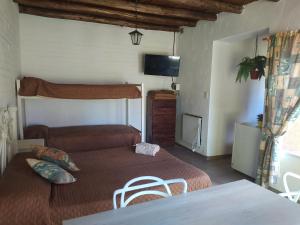 a room with two beds and a tv and a table at Posada Uspallata in Uspallata