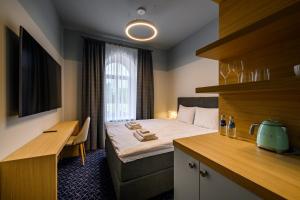 um quarto de hotel com uma cama e uma secretária em Roze Village Jūrnieka Ligzda em Pērkone