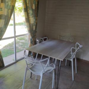 mesa y sillas en una habitación con ventana en Posada Uspallata en Uspallata