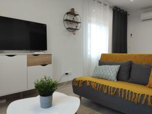 - un salon avec un canapé et une télévision dans l'établissement Apartamento Rodhes playa 2-A5, à Roses