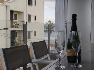 - une bouteille de vin et deux verres sur une table dans l'établissement Apartamento Rodhes playa 2-A5, à Roses