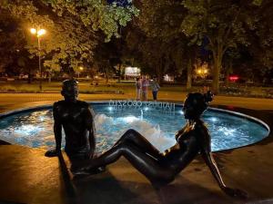 Una statua di un uomo e una donna seduti in una fontana di Apartman Pávai-Silye a Hajdúszoboszló