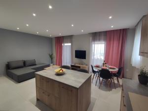 a living room with a couch and a table with chairs at Nostalgia Apartment in Archangelos