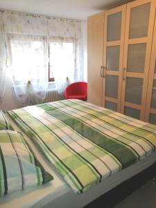 ein Bett in einem Schlafzimmer mit einem roten Stuhl in der Unterkunft Ferienwohnung Guth in Wehr
