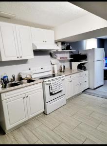 a kitchen with white cabinets and white appliances at Staycation Apartment, Free Parking ,kitchen & washroom ensuite in London