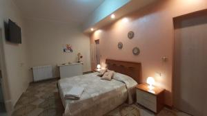 Un dormitorio con una cama con dos luces. en B&B Affittacamere La Dolce Mela, en Francavilla di Sicilia