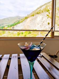 einen Martini auf einem Holztisch vor einem Fenster in der Unterkunft Praia Sea Home, Casa Vacanze in Praia a Mare