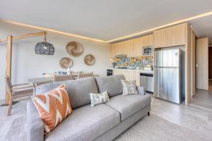 a living room with a couch and a kitchen at Lumina at Cardinal San José del Cabo in San José del Cabo