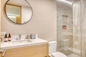 a bathroom with a sink and a shower with a mirror at Lumina at Cardinal San José del Cabo in San José del Cabo