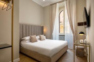 1 dormitorio con cama blanca y ventana en Porta Castello Suites, en Roma