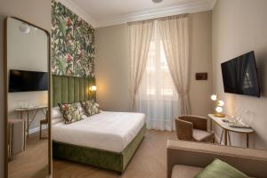 Habitación de hotel con cama y silla en Porta Castello Suites, en Roma