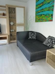 un sofá negro en una sala de estar con una pintura en Ferienwohnung Guth en Wehr