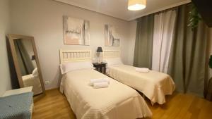 a room with two beds with towels on them at Aires de Toledo-Parque Warner y Madrid en familia in Toledo