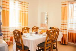 uma sala de jantar com uma mesa branca e cadeiras em Kwe Decasa em Kisumu