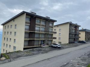 an apartment building with a car parked in front of it at Refuge St Lary in Saint-Lary-Soulan