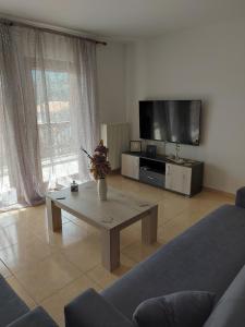 a living room with a coffee table and a flat screen tv at Ina House in Samos