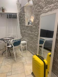 een kamer met een tafel en een gele koffer bij Il Moretto in Trani