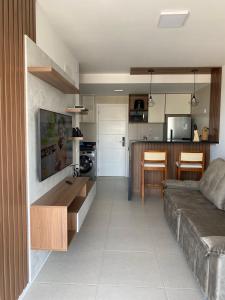 a living room with a couch and a kitchen at Studio 1quarto Vista Mar Barra in Salvador +23 photos