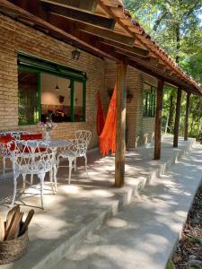 een patio met een tafel en stoelen voor een gebouw bij Casa charmosa em condomínio arborizado in Nova Lima