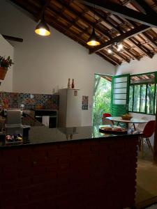 een keuken met een aanrecht en een tafel met stoelen bij Casa charmosa em condomínio arborizado in Nova Lima