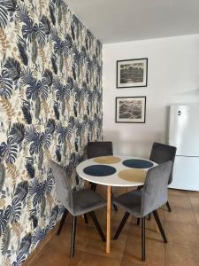 a kitchen with a table and chairs and a refrigerator at Apartament Oksford in Okszów +10 photos