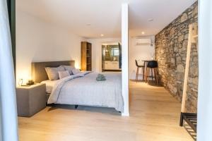 1 dormitorio con cama y pared de piedra en Villa Harmony, en Supetar