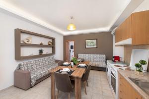 a kitchen and living room with a table and a couch at Savvas Apartment in Afantou